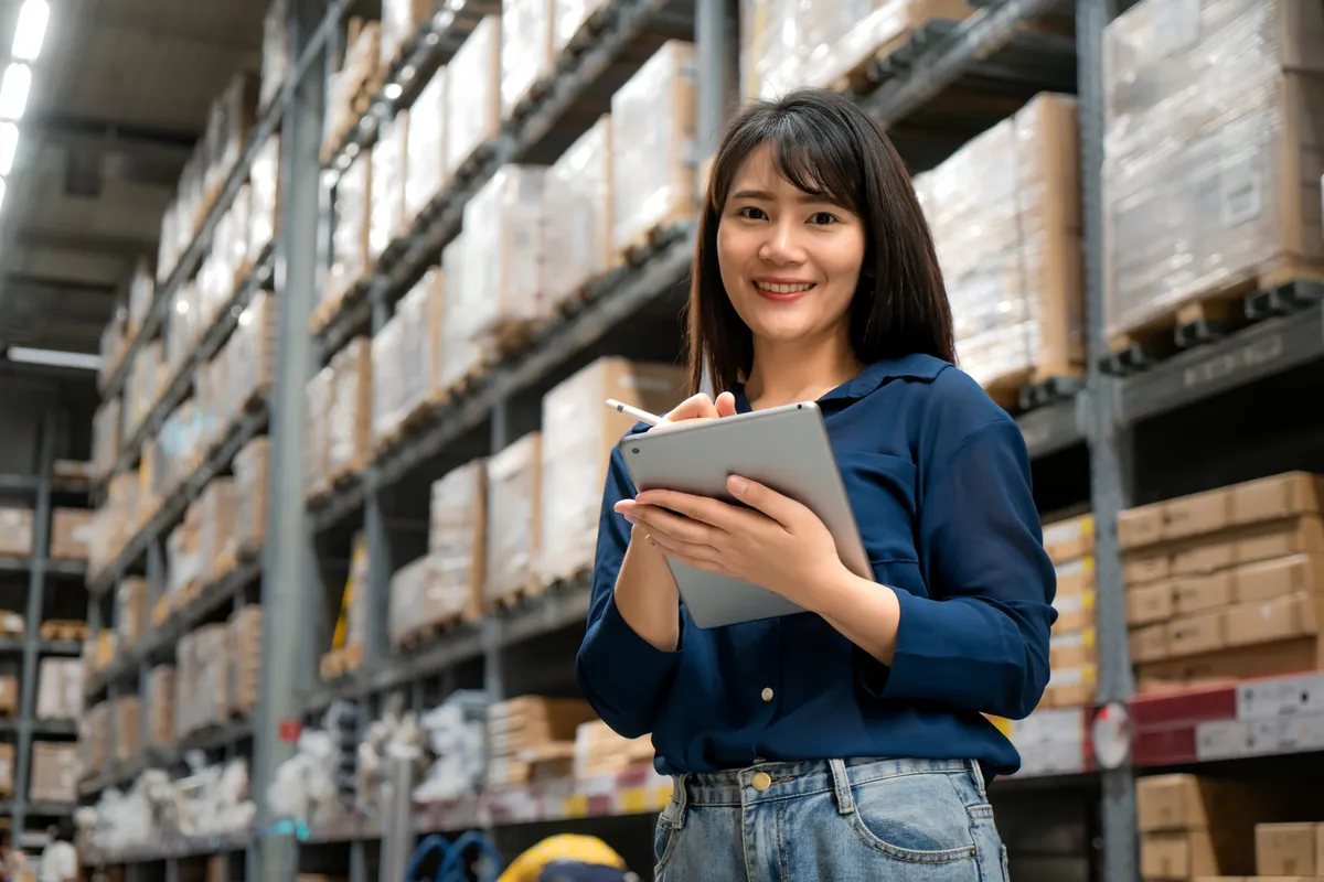 An operations manager checking stock on a tablet in a warehouse