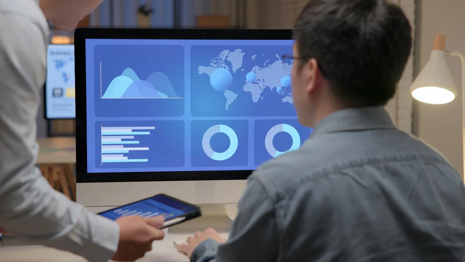 Analysts reviewing dashboards together on a large screen