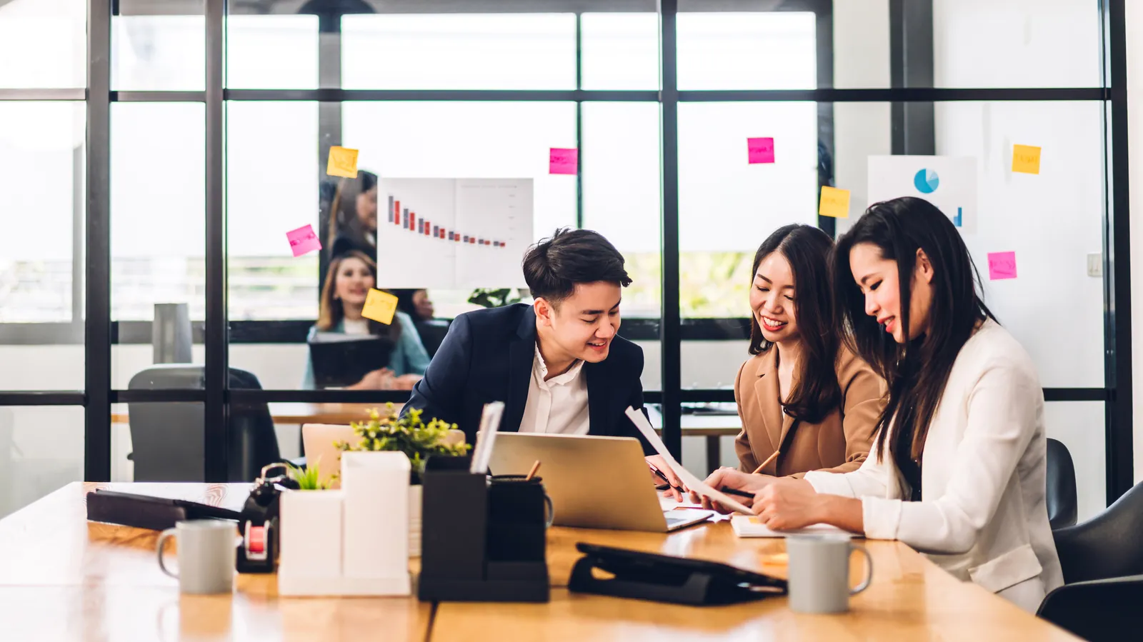 A team reviewing work together on a laptop in a bright office